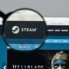Lupa powiększa logo Steam. Użytkownik szuka informacji o adresie rozliczeniowym Steam, przeglądając stronę główną platformy z grami.