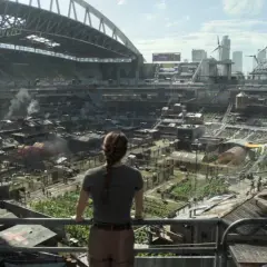 Widok na postapokaliptyczne miasto wewnątrz stadionu, gdzie ludzie żyją w prowizorycznych domach. Może to być scena z The Last of Us sezon 3.