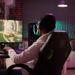 Gracz w słuchawkach z mikrofonem zanurzony w wirtualnym świecie gry fps.
