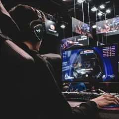 Gracz w słuchawkach z podświetlanym logo ROG zanurzony w akcji gry typu extraction shooter.