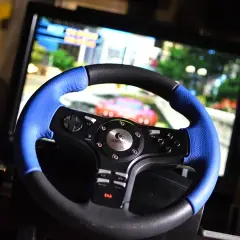 Kierownica Logitech do gry komputerowej, z niebieskimi akcentami, gotowa do wyścigów na ekranie.