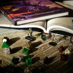 Księga D&D, kostki i figurki na mapie miasta. Przygotowania do epickiej sesji dungeon crawler.