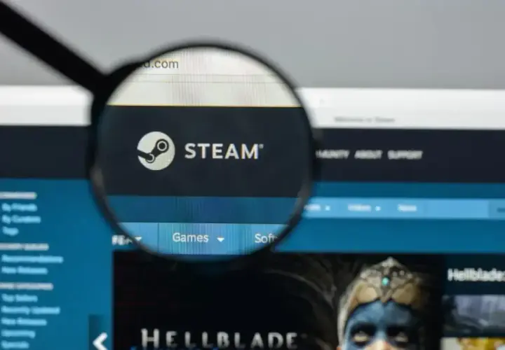Lupa powiększa logo Steam. Użytkownik szuka informacji o adresie rozliczeniowym Steam, przeglądając stronę główną platformy z grami.