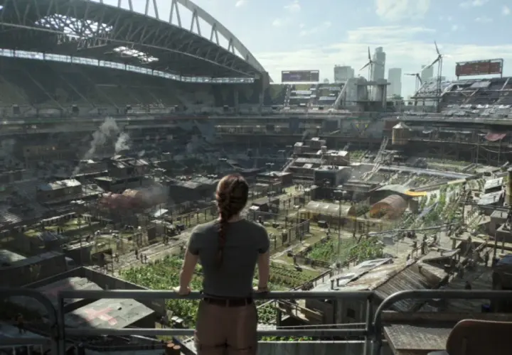 Widok na postapokaliptyczne miasto wewnątrz stadionu, gdzie ludzie żyją w prowizorycznych domach. Może to być scena z The Last of Us sezon 3.