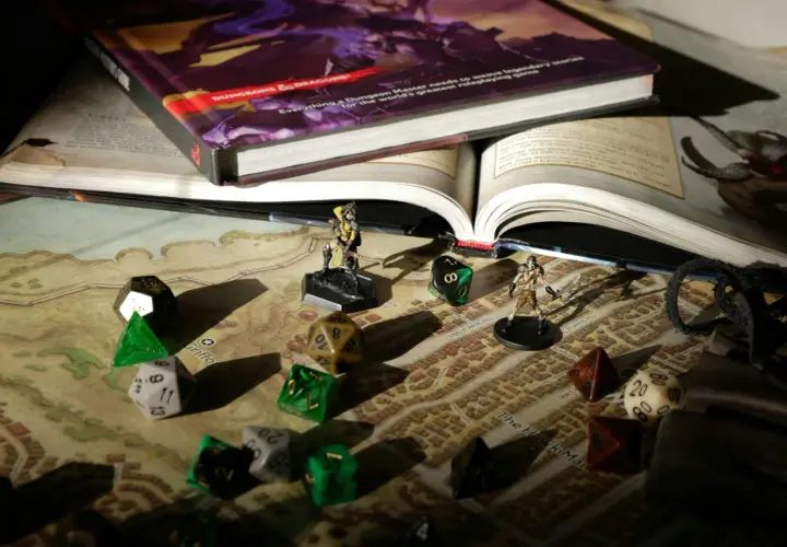 Księga D&D, kostki i figurki na mapie miasta. Przygotowania do epickiej sesji dungeon crawler.
