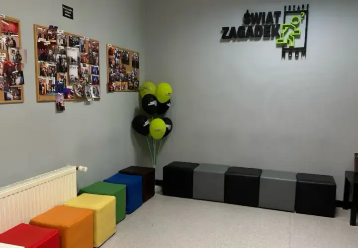W poczekalni "Świat Zagadek" wiszą zdjęcia z przygód, balony i kolorowe pufy.
