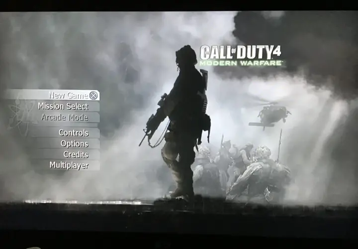 Menu gry Call of Duty 4: Modern Warfare. W tle żołnierze i helikopter.
