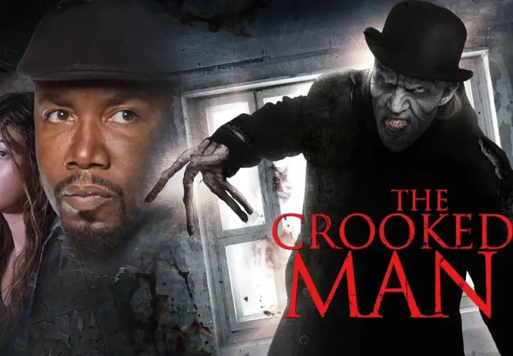 Przerażający, pokręcony mężczyzna w kapeluszu zbliża się do przerażonej kobiety i mężczyzny. Tytuł filmu: "The Crooked Man".