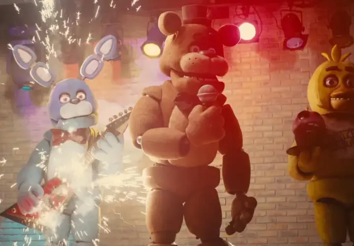 Freddy, Bonnie i Chica z filmu FNAF na scenie. Bonnie gra na gitarze, Freddy śpiewa, a Chica trzyma babeczkę.