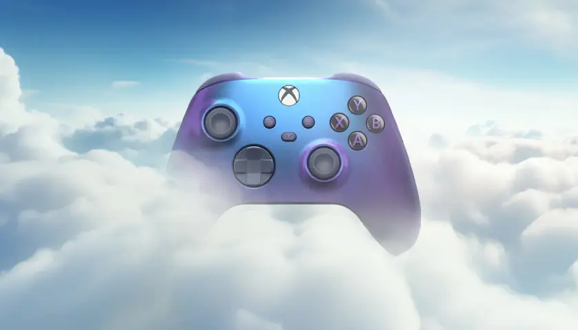 Kontroler Xboxa w tęczowych barwach unosi się wśród puszystych chmur, symbolizując granie w chmurze i nieograniczone możliwości.