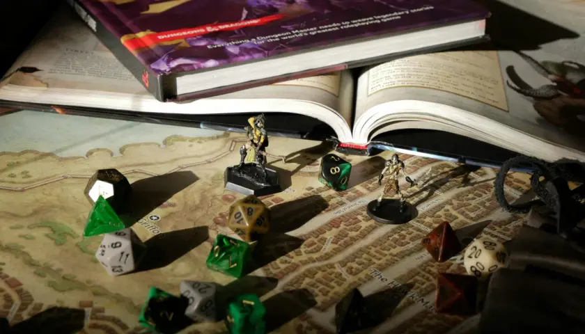 Księga D&D, kostki i figurki na mapie miasta. Przygotowania do epickiej sesji dungeon crawler.