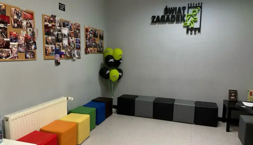 W poczekalni "Świat Zagadek" wiszą zdjęcia z przygód, balony i kolorowe pufy.