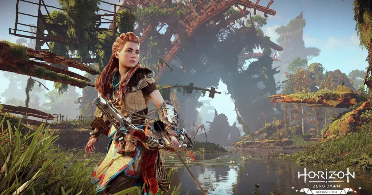 Aloy w Horizon Zero Dawn Remastered, z łukiem w ręku, stoi nad wodą wśród bujnej roślinności i zrujnowanych budowli.