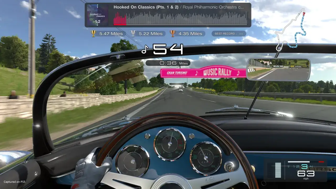 Wnętrze klasycznego samochodu w grze Gran Turismo 8, widok z perspektywy kierowcy. Na desce rozdzielczej widać prędkościomierz i obrotomierz.