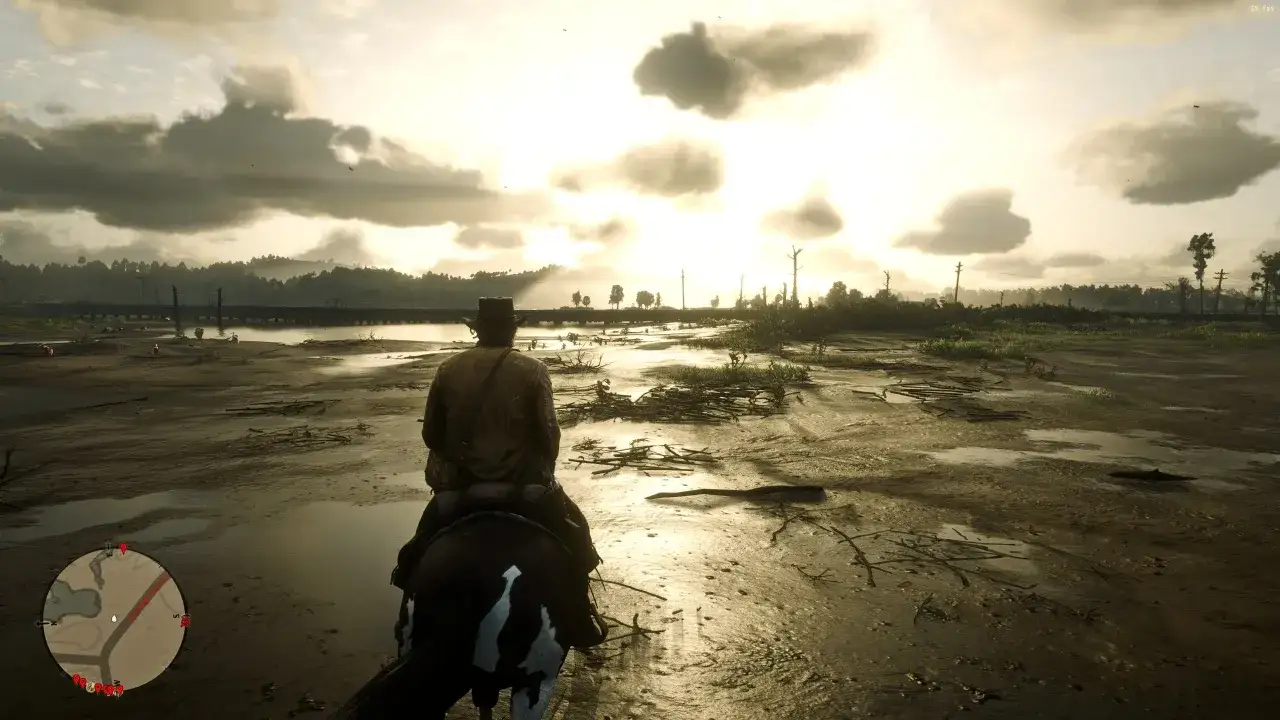 Jeździec na koniu przemierza błotniste tereny w grze Red Dead Redemption 2 PC. Słońce przebija się przez chmury, tworząc złocistą poświatę.